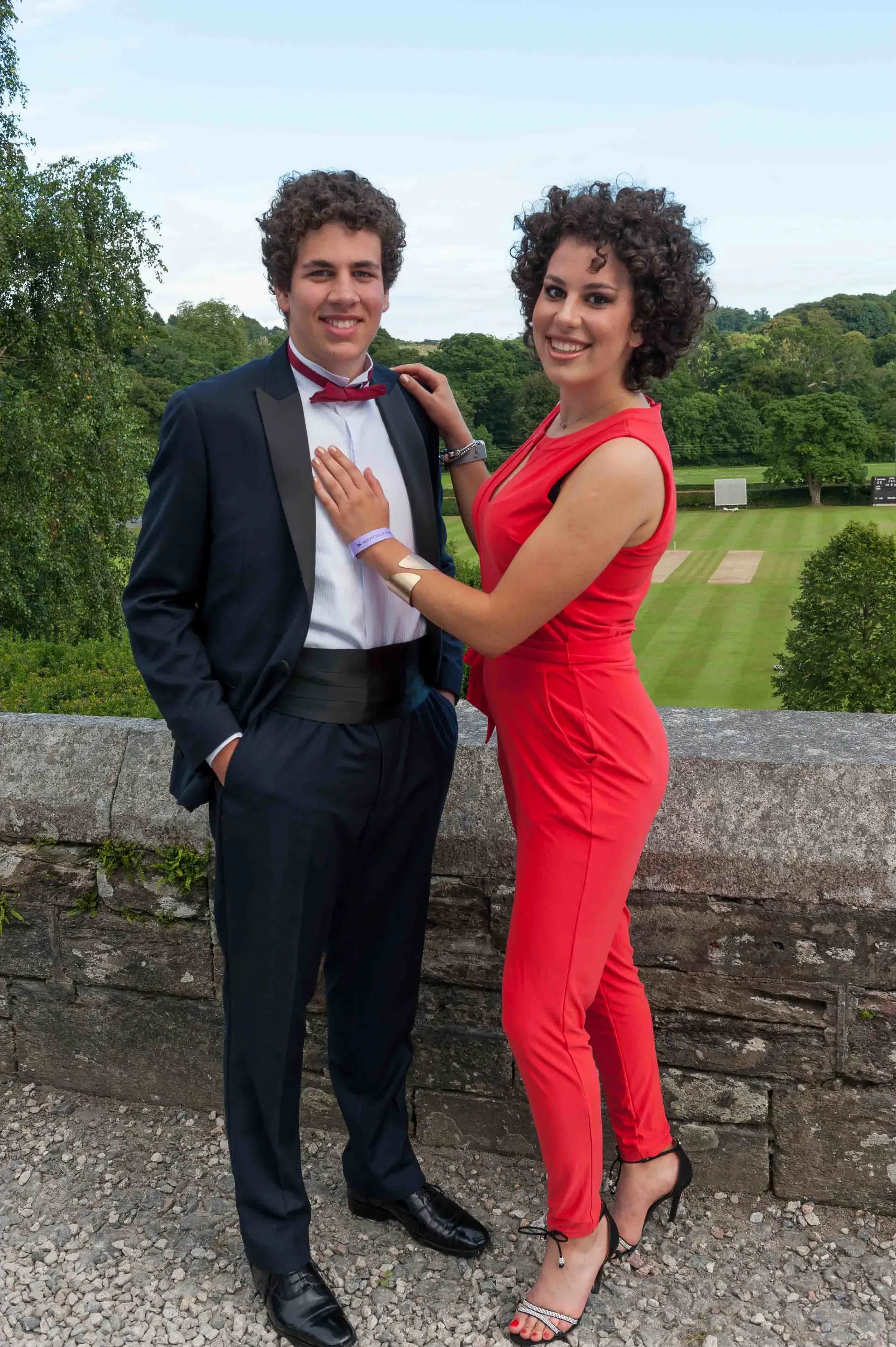 Romantic couple pose on stone balustrade overlooking grounds