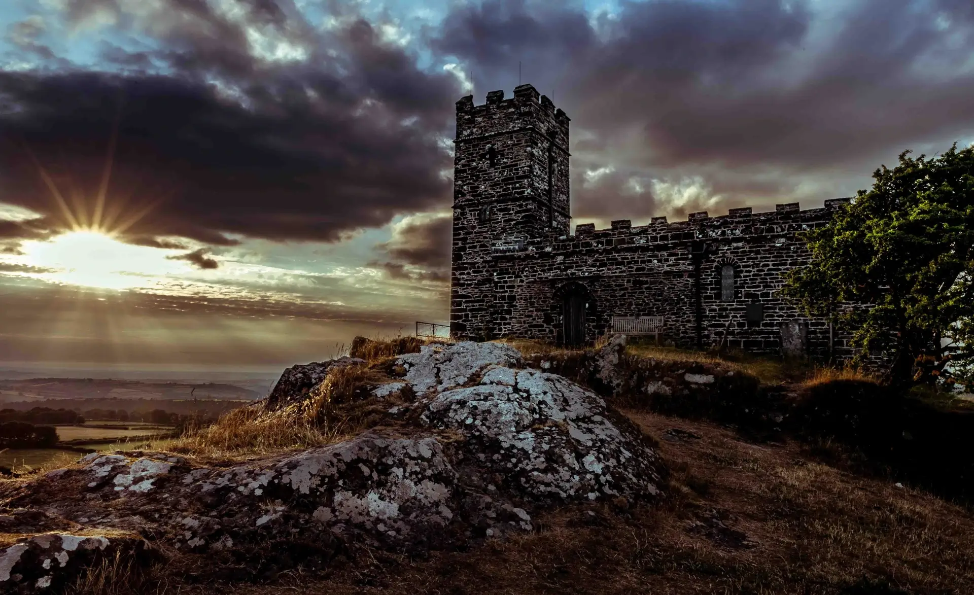 Historic castle ruins against dramatic sunset sky